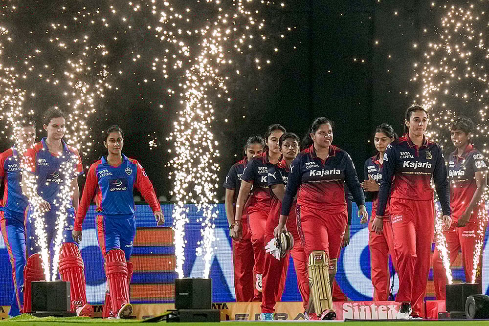 | Photo: PTI/Kunal Patil : Delhi Capitals captain Jemimah Rodrigues, in blue, and Royal Challengers Bengalurus captain Smriti Mandhana with their respective teammates enter the field during the start of the Womens Premier League (WPL) 2026 final T20 cricket match between Delhi Capitals and Royal Challengers Bengaluru, at Baroda Cricket Association Stadium, Kotambi in Vadodara, Gujarat.