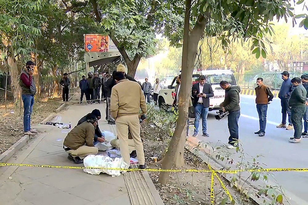 | Photo: PTI : Police personnel investigate the spot after two wanted persons were arrested following a brief encounter, at RK Puram area, in New Delhi.