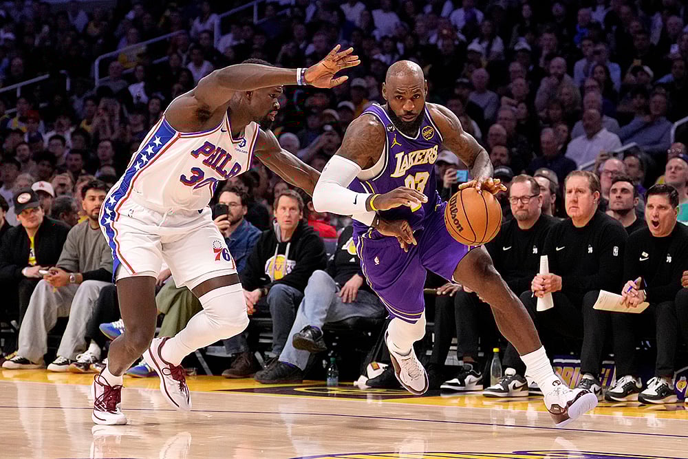 | Photo: AP/Mark J. Terrill : Los Angeles Lakers forward LeBron James, right, drives by Philadelphia 76ers center Adem Bona during the second half of an NBA basketball game in Los Angeles. 