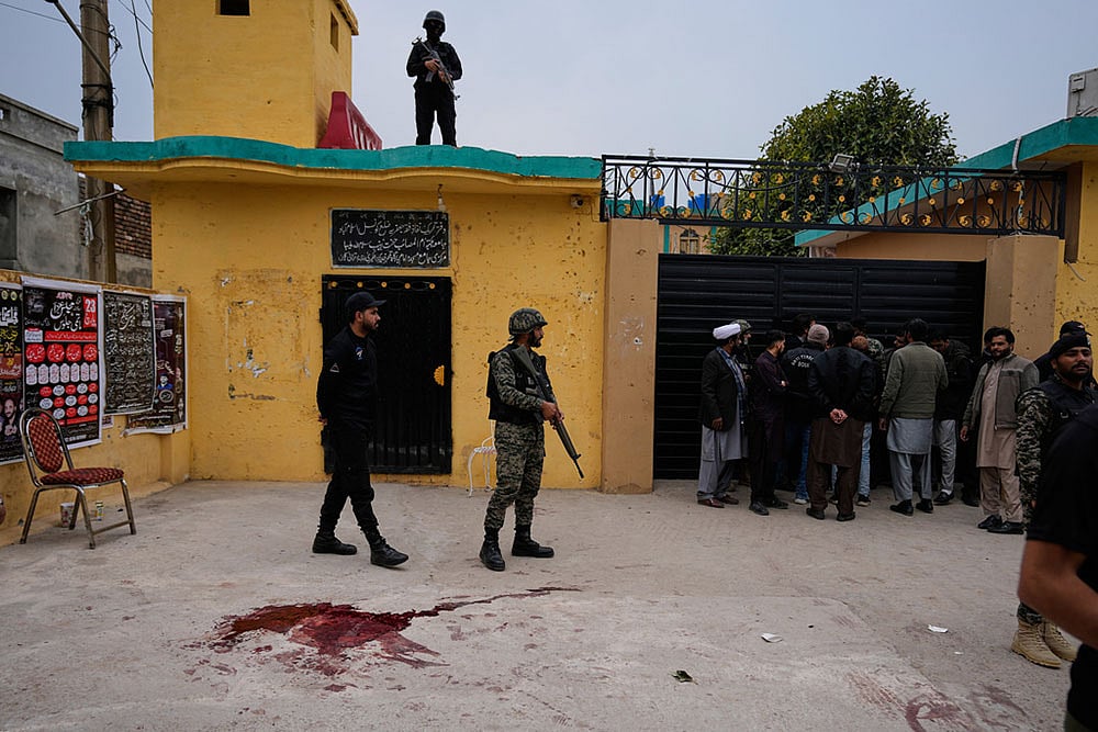 Photo: AP/Anjum Naveed : Pakistani paramilitary and police commandos take positions at the site of a bomb explosion at a Shiite mosque, in Islamabad, Pakistan.