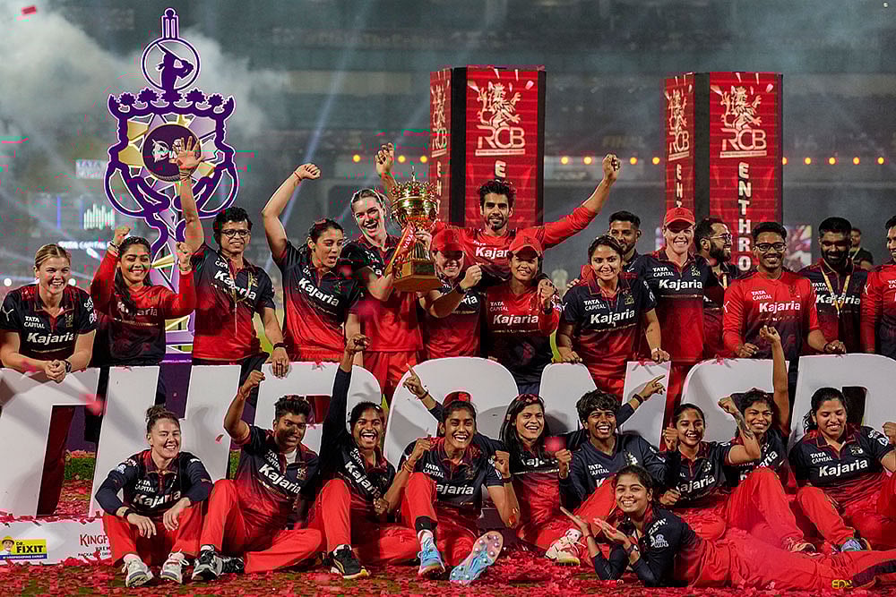 | Photo: PTI/Kunal Patil : Royal Challengers Bengalurus players celebrate with the trophy after winning the Womens Premier League (WPL) 2026 final T20 cricket match against Delhi Capitals, at Baroda Cricket Association Stadium, Kotambi in Vadodara, Gujarat.