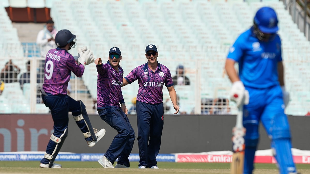 (AP Photo/Bikas Das) : Scotlands Matthew Cross, left, celebrates with teammates the wicket of Italys Justin Mosca, right, with teammate of during the T20 World Cup cricket match between Italy and Scotland in Kolkata, India, Monday, Feb. 9, 2026