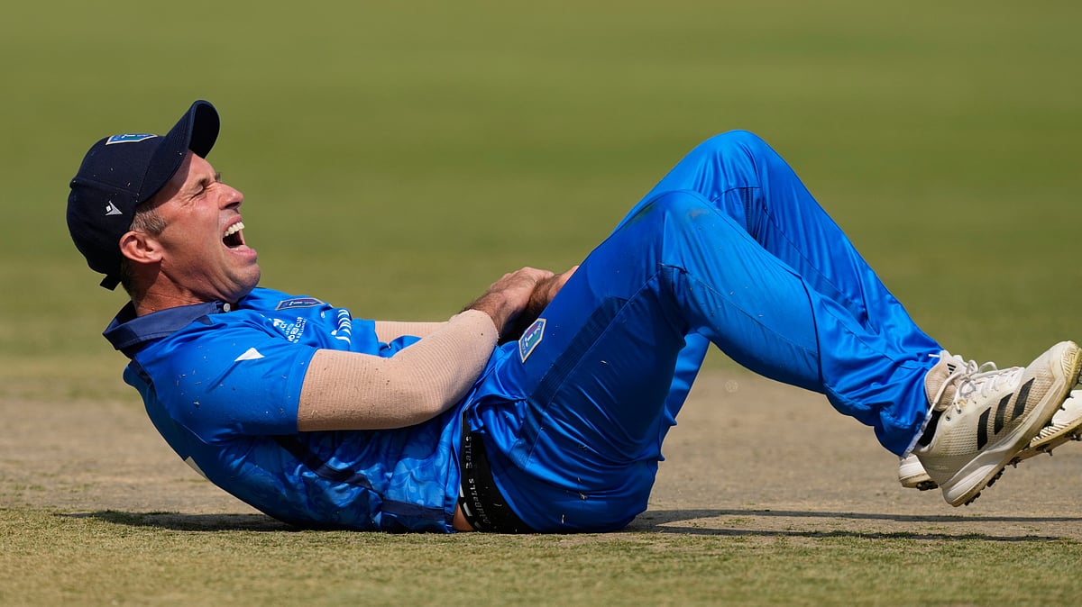 (AP Photo/Bikas Das) : Italys captain Wayne Madsen reacts after a miss-fielding by him which hurt his hand during the T20 World Cup cricket match between Italy and Scotland in Kolkata, India, Monday, Feb. 9, 2026