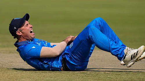 (AP Photo/Bikas Das) : Italys captain Wayne Madsen reacts after a miss-fielding by him which hurt his hand during the T20 World Cup cricket match between Italy and Scotland in Kolkata, India, Monday, Feb. 9, 2026