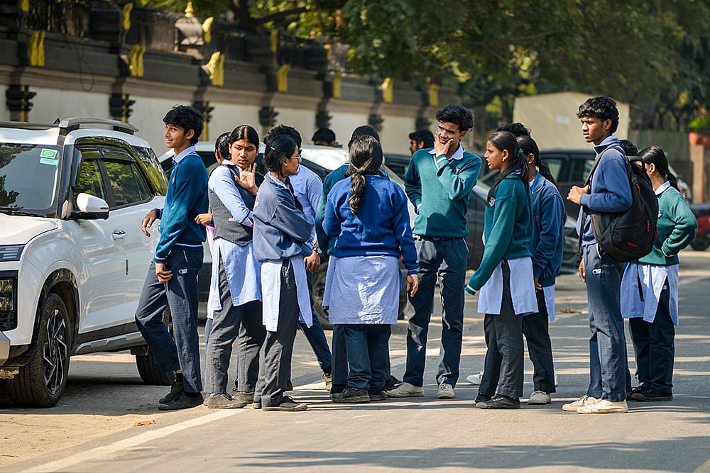 | Photo: PTI : Students stand outside DTA Tamil School after it received a bomb threat, in New Delhi. More than a dozen schools across the national capital received bomb threat emails. 