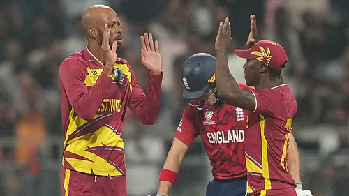 Photo: AP : West Indies Roston Chase, left, celebrates with teammates the wicket of Englands Jos Buttler during their T20 World Cup match in Mumbai.