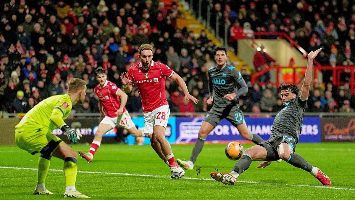 (Martin Rickett/PA via AP) : Ipswich Town's Jacob Greaves, right, blocks a cross as Wrexham's Sam Smith (28) looks on during an English FA Cup fourth round soccer, Friday, Feb. 13, 2026, in Wrexham, Wales.