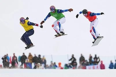 | Photo: AP/Lindsey Wasson : United States Nathan Pare (13), Frances Jonas Chollet (4) and Frances Loan Bozzolo (5) compete during the mens snowboard cross finals at the 2026 Winter Olympics, in Livigno, Italy.
