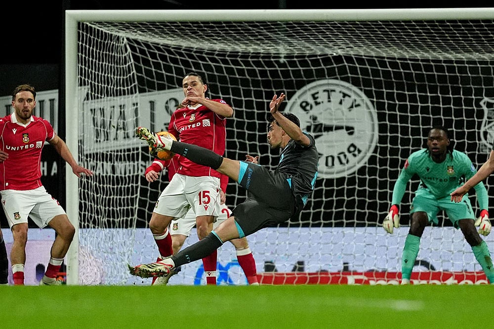 | Photo: Martin Rickett/PA via AP : Ipswich Towns Jacob Greaves, front, has a shot at goal blocked by Wrexhams George Dobson (15) during an English FA Cup fourth round soccer in Wrexham, Wales.