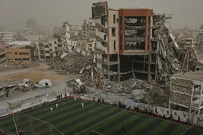 | Photo: AP/Jehad Alshrafi : Palestinian players of Gaza Sports Club and Al-Ahly Club take part in a soccer match at a newly constructed field surrounded by buildings destroyed in Israeli ground and air operations, in Gaza City.