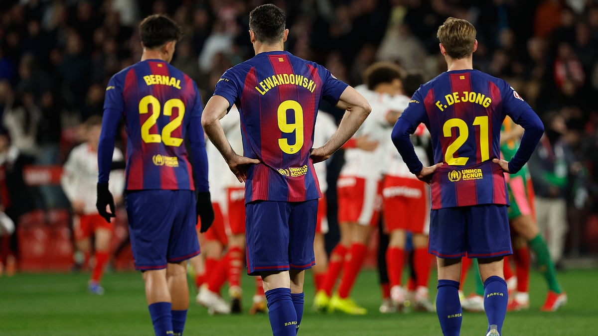 | Photo: AP/Joan Monfort : Barcelona's Frenkie de Jong, Marc Bernal and Robert Lewandowski react as Girona player celebrate after winning a Spanish La Liga soccer match between Girona and Barcelona in Girona, Spain, Monday, Feb. 16, 2026. 