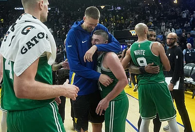 | Photo: AP/Jeff Chiu : Golden State Warriors center Kristaps Porziņģis, top middle, hugs Boston Celtics guard Payton Pritchard as Celtics guard Derrick White (9) hugs Warriors guard Gary Payton II after an NBA basketball game in San Francisco.