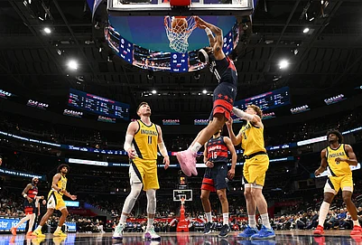 | Photo: AP/Nick Wass : Washington Wizards guard Alondes Williams (31) reverse dunks over Indiana Pacers center Micah Potter (11) and guard Taelon Peter (4) during the second half of an NBA basketball game in Washington.