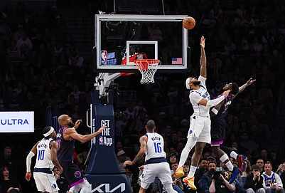 | Photo: AP/Lily Dozier : Dallas Mavericks Daniel Gafford, second from right, leaps to block a shot by Minnesota Timberwolves Anthony Edwards, right, during the second half of an NBA basketball game in Minneapolis.
