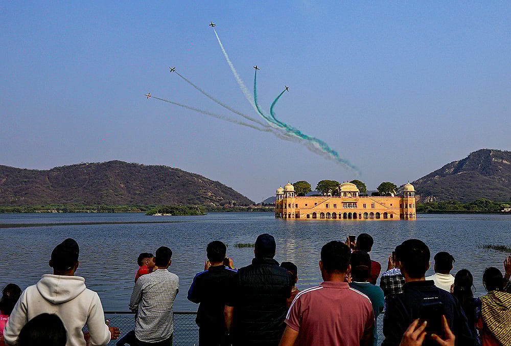 | Photo: PTI : Indian Air Forces (IAF) Surya Kiran Aerobatic Team (SKAT) performs manoeuvres over the Jal Mahal during full dress rehearsal ahead of the Sarang and Surya Kiran Air Show, in Jaipur, Rajasthan.