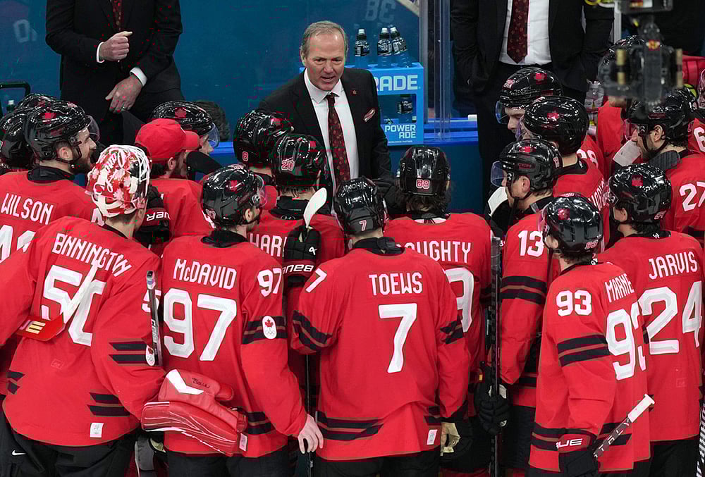 | Photo: AP/Carolyn Kaster : Canada head coach Jon Cooper talks with his players after their win against Finland in a mens ice hockey semifinal game at the 2026 Winter Olympics in Milan, Italy.