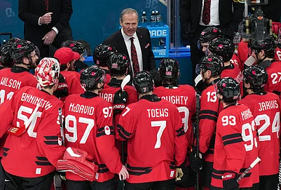 | Photo: AP/Carolyn Kaster : Canada head coach Jon Cooper talks with his players after their win against Finland in a mens ice hockey semifinal game at the 2026 Winter Olympics in Milan, Italy.