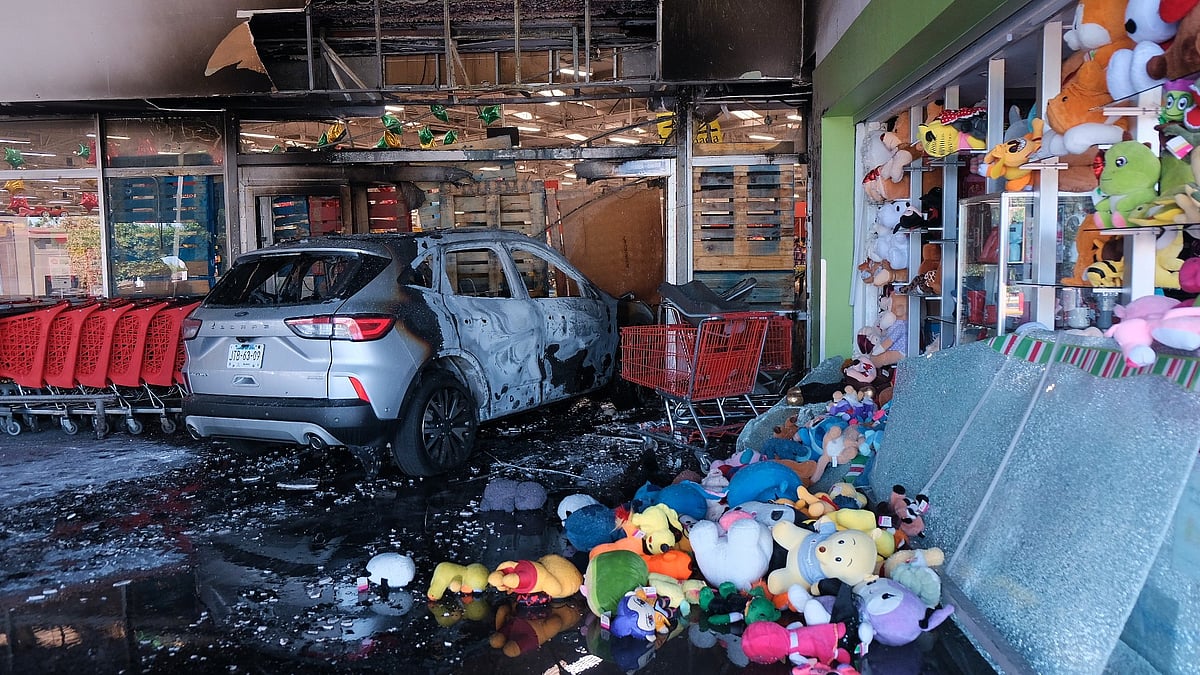 (AP Photo/Alejandra Leyva) : A charred vehicle sits at a damaged supermarket in Guadalajara, Jalisco state, Mexico, Sunday, Feb. 22, 2026, after the death of the leader of the Jalisco New Generation Cartel, Nemesio Rubén Oseguera Cervantes, known as El Mencho. 