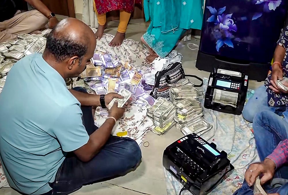 | Photo: PTI : Odisha Vigilance officials count seized cash during a raid at the residence of arrested Deputy Director of Mines Debabrata Mohanty in connection with a bribery case, in Bhubaneswar. Over Rs 4 crore in cash was recovered during the raids, officials said. 