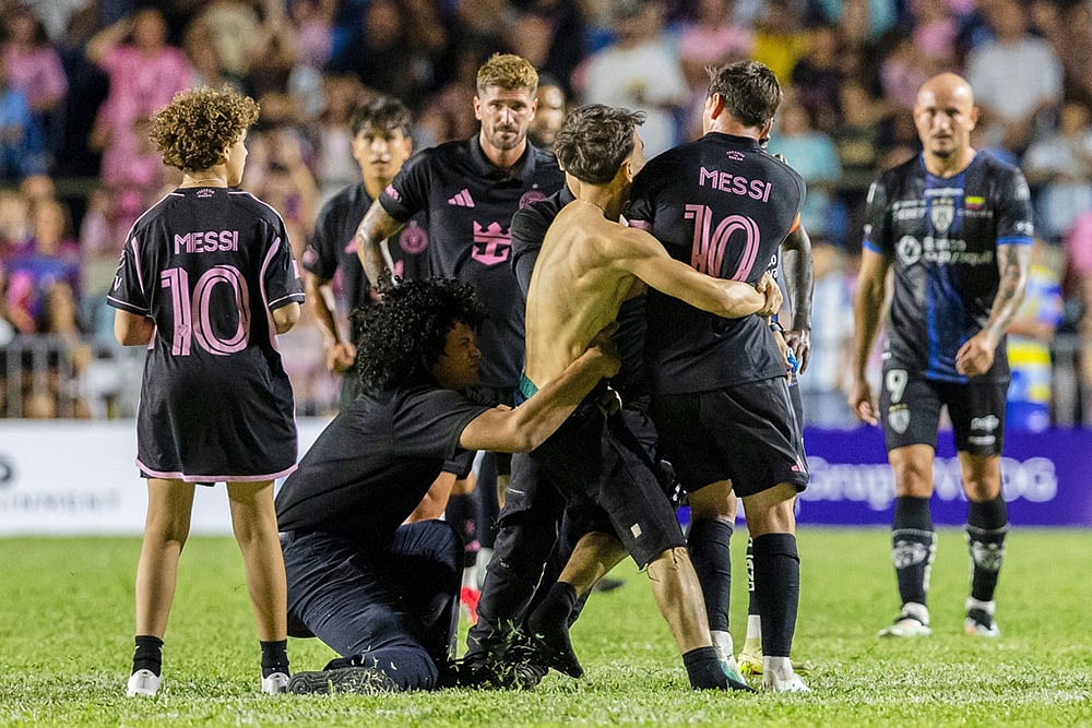 | Photo: AP/Alejandro Granadillo : A fan who got onto the field grabs Inter Miamis Lionel Messi at the end of an international friendly soccer match against Ecuadors Independiente del Valle in Bayamon, Puerto Rico.