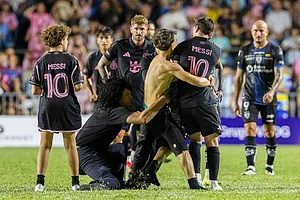 | Photo: AP/Alejandro Granadillo : A fan who got onto the field grabs Inter Miami's Lionel Messi at the end of an international friendly soccer match against Ecuador's Independiente del Valle in Bayamon, Puerto Rico.