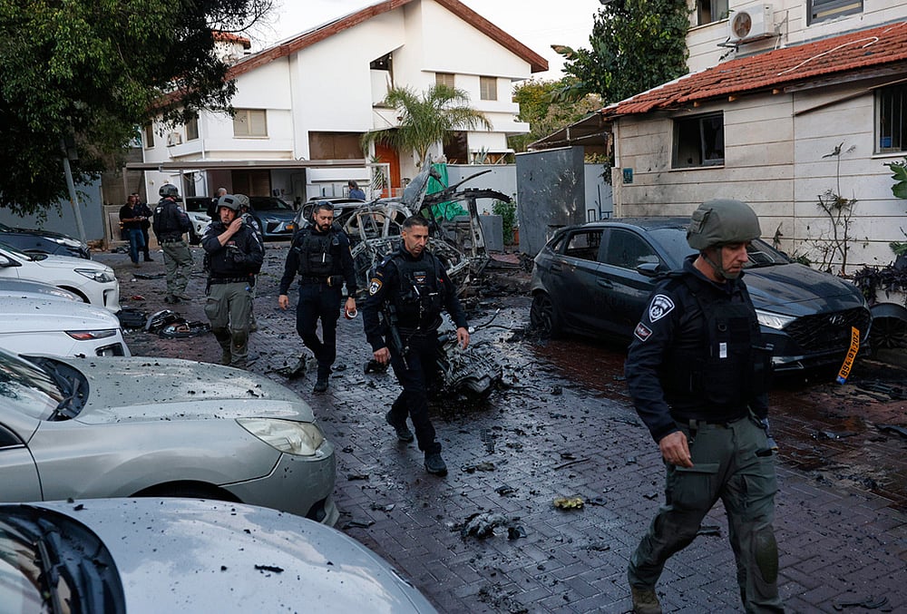 | Photo: AP/Tomer Appelbaun : Israeli policemen survey a missile attack from Iran in Rosh HaAyin, Israel.