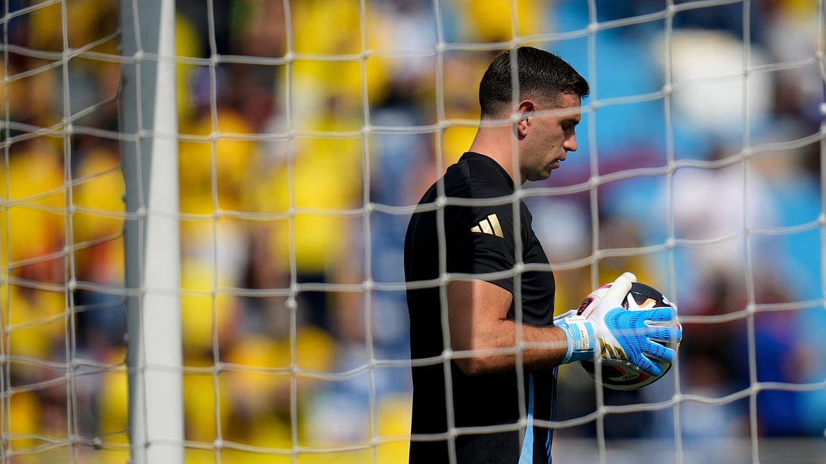 (AP Photo/Fernando Vergara) : Argentina's goalkeeper Emiliano Martinez holds a ball while warming up prior to a qualifying soccer match against Colombia for the FIFA World Cup 2026 at the Metropolitano Roberto Melendez stadium in Barranquilla, Colombia, Tuesday, Sept. 10, 2024. 