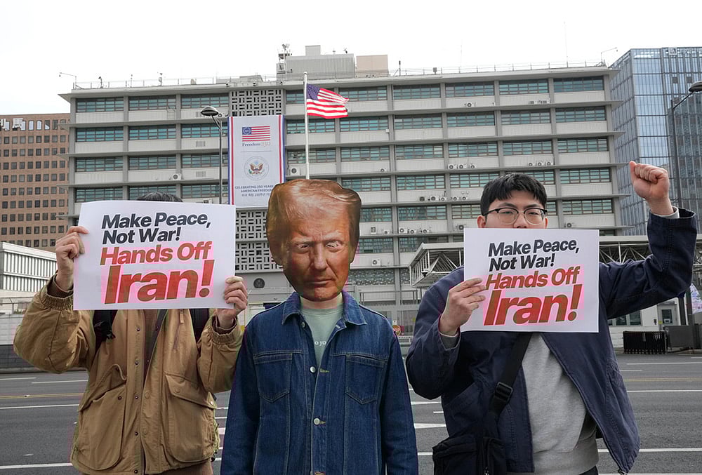 | Photo: AP/Ahn Young-joon : A South Korean protester wearing a mask of U.S. President Donald Trump attends a press conference denouncing the U.S. and Israels attack on Iran, near the U.S. Embassy in Seoul, South Korea.