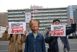 | Photo: AP/Ahn Young-joon : A South Korean protester wearing a mask of U.S. President Donald Trump attends a press conference denouncing the U.S. and Israels attack on Iran, near the U.S. Embassy in Seoul, South Korea.