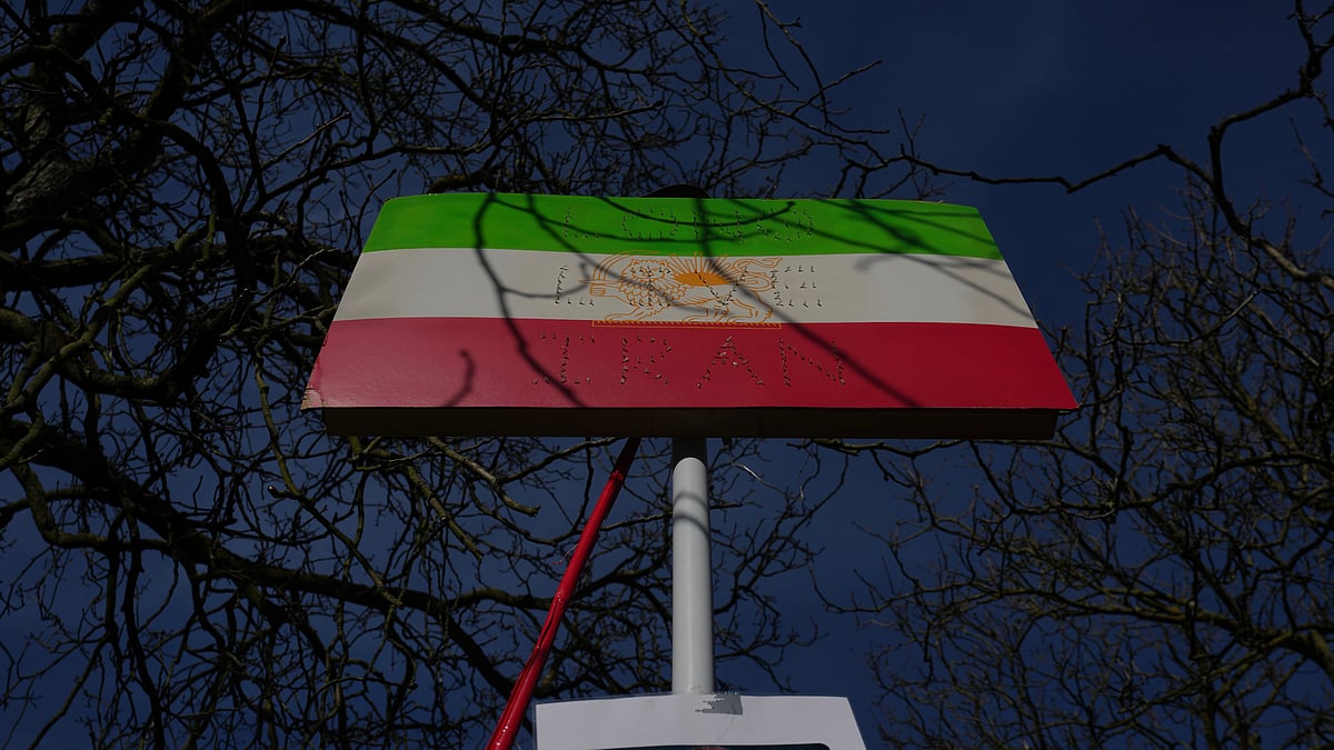 | Photo: AP/Kin Cheung : A historic Iranian national flag is displayed by protesters outside the Iranian Embassy in London, Monday, March 2, 2026. 
