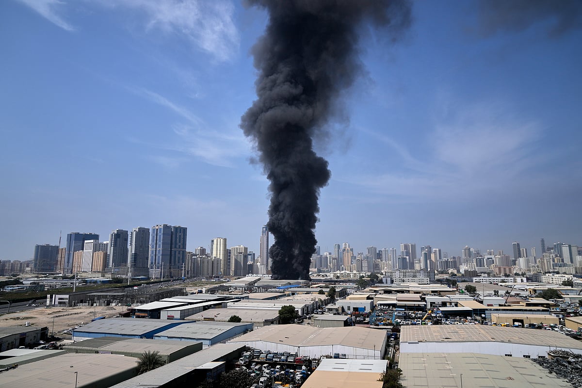 Altaf Qadri; AP : A black plume of smoke rises from a warehouse at the industrial area of Sharjah City in the United Arab Emirates following reports of Iranian strikes in Dubai, United Arab Emirates, Sunday, March 1, 2026. 