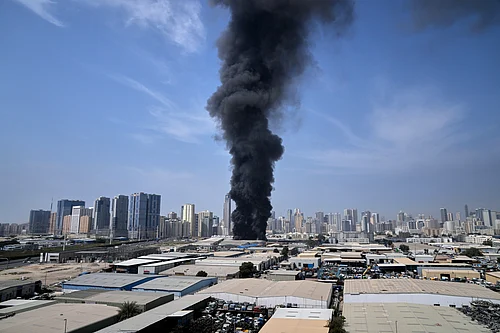 Altaf Qadri; AP : A black plume of smoke rises from a warehouse at the industrial area of Sharjah City in the United Arab Emirates following reports of Iranian strikes in Dubai, United Arab Emirates, Sunday, March 1, 2026.