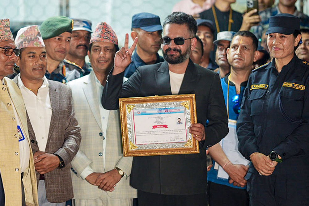 Photo: PTI : Balendra Shah, a candidate of the Rastriya Swatantra Party (RSP) from Jhapa Constituency-5, shows a certificate at the Election Commission premises after winning the constituency in the Nepal general elections, in Jhapa, Nepal. Balendra Shah Balen defeated four-time prime minister K P Sharma Oli by a huge margin of about 50,000 votes. 