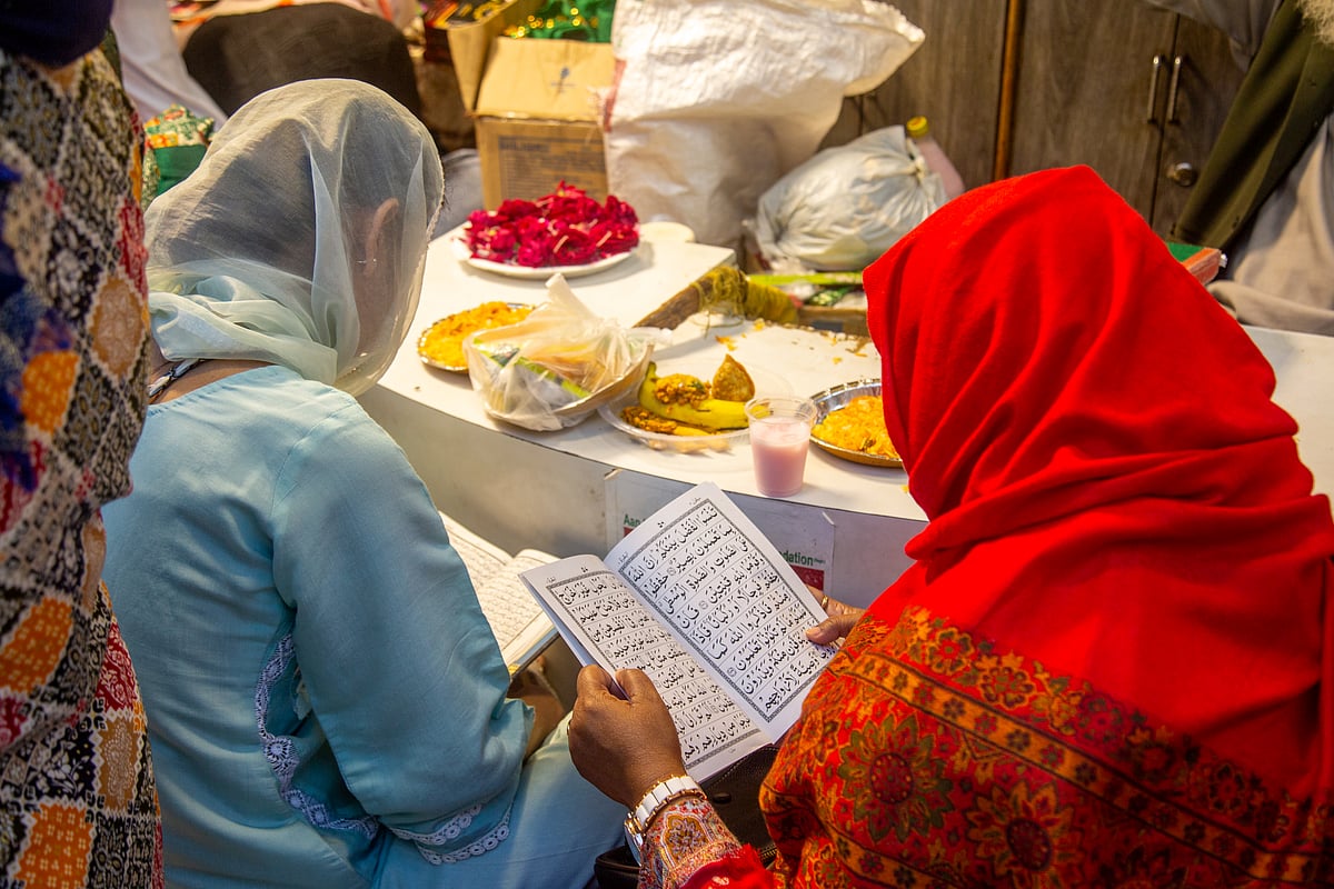 Noor Nisha : Two women read while waiting to break their fast at Nizamuddin Dargah during Ramadan.