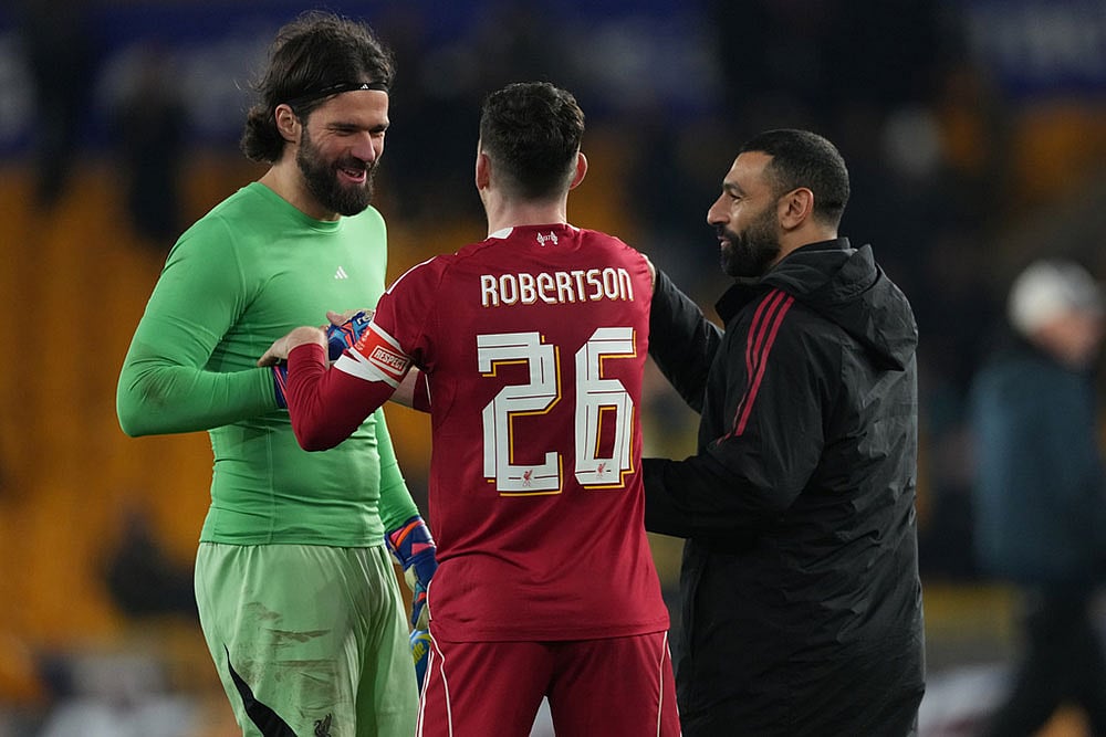 | Photo: AP/Dave Shopland : Liverpools goalkeeper Alisson, left Liverpools Andrew Robertson, center, and Liverpools Mohamed Salah celebrate at the end of the English FA Cup soccer match between Wolves and Liverpool in Wolverhampton, England.