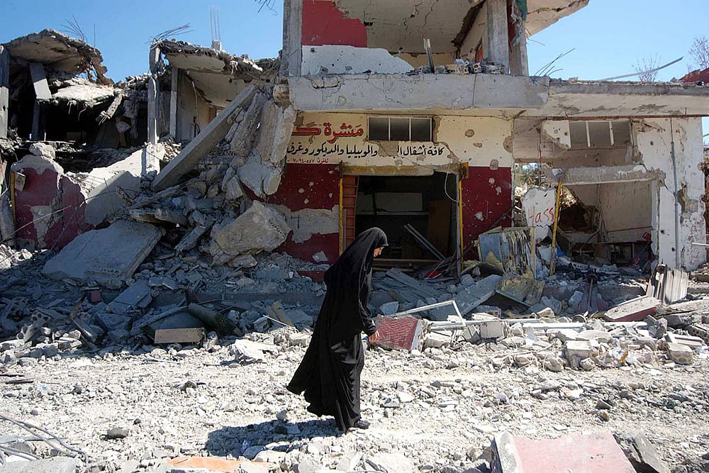 Photo: Imago : A Lebanese woman makes her way trough the debris covered street of a village that was almost completely destroyed by Israeli bombing.