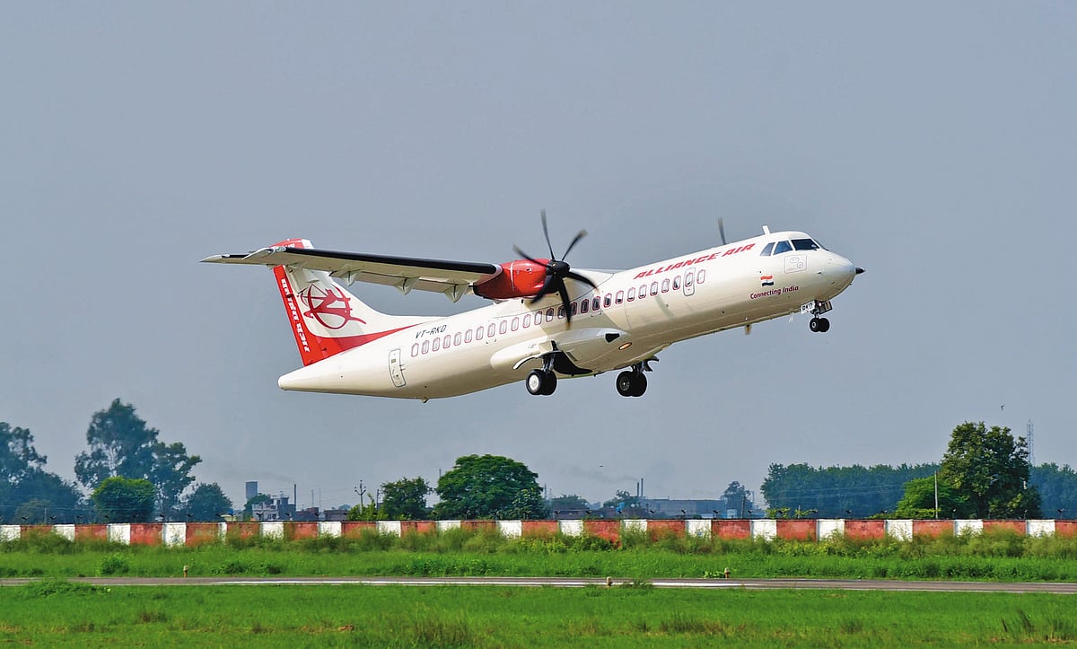 Alliance Air regional aircraft departs the airport, climbing above a grassy runway in Uttar Pradesh