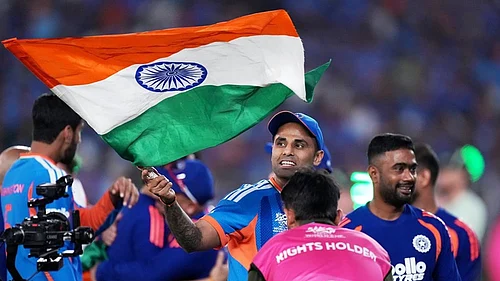 | Photo: AP/Ajit Solanki : Indias captain Suryakumar Yadav carries the Indian national flag after winning the T20 World Cup cricket final match against New Zealand in Ahmedabad.