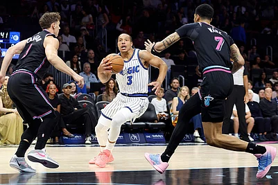 | Photo: AP/Rhona Wise : Miami Heat guard Pelle Larsson (9) and Miami Heat Kelel Ware (7) defend Orlando Magic guard Desmond Bane (3) during the first half of an NBA basketball game in Miami.