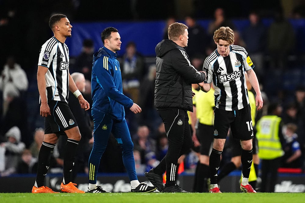 | Photo: John Walton/PA via AP : Newcastle Uniteds Anthony Gordon, right, is congratulated by manager Eddie Howe following victory in the Premier League match between Chelsea and Newcastle, in London.