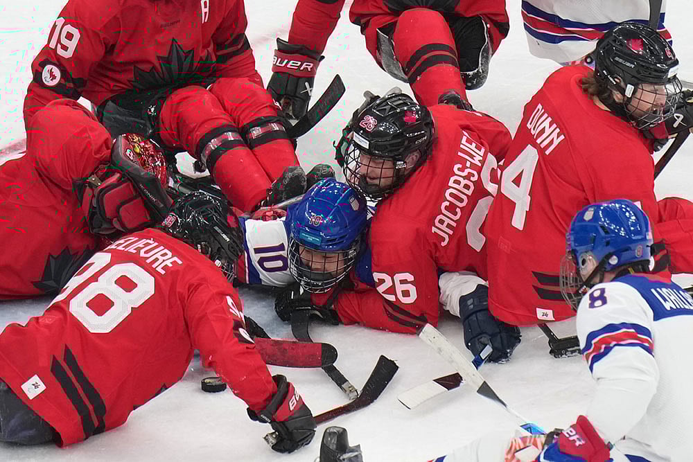 | Photo: AP/Antonio Calanni : United States Brett Bolton, center, challenges for the puck with Canadas Anton Jacobs-Webb during the ice hockey gold medal match between United States and Canada at the 2026 Winter Paralympics, in Milan, Italy.