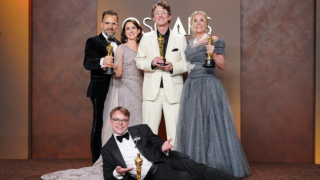 (Photo by Jordan Strauss/Invision/AP) : Pavel Talankin, front center, and Radovan Sibrt, top left, Alzbeta Karaskova, David Borenstein, and Helle Faber, winners of the award for documentary feature film for Mr. Nobody against Putin, pose in the press room at the Oscars on Sunday, March 15, 2026, at the Dolby Theatre in Los Angeles. 