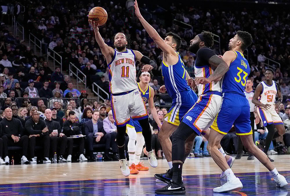| Photo: AP/Seth Wenig : New York Knicks Jalen Brunson (11), left, drives to the basket past Golden State Warriors defenders during the second half of an NBA basketball game in New York. 
