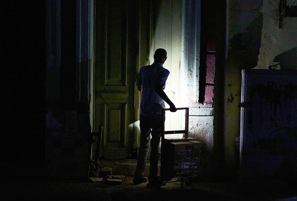 | Photo: AP/Ramon Espinosa : A man enters his building during a blackout in Havana, Monday, March 16, 2026. 