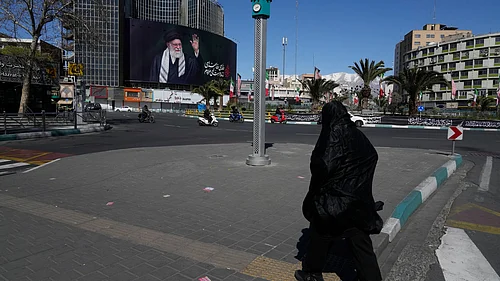 AP : A woman crosses almost deserted square with a billboard at rear showing a portrait of the late Iranian Supreme Leader Ayatollah Ali Khamenei, who was killed in the U.S.–Israeli military campaign, in Tehran, Iran, Tuesday, March 3, 2026. (AP Photo/Vahid Salemi)