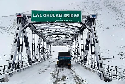 | Photo: PTI : A vehicle passes through the snow-covered Lal Ghulam Bridge following fresh snowfall, in Rajouri, Jammu and Kashmir.