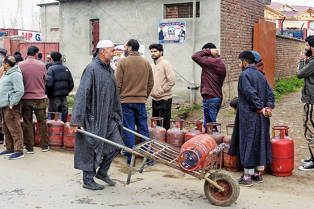 | Photo; PTI : Stocking Up: People line up to carry LPG cooking gas cylinders home in Pulwama, Kashmir