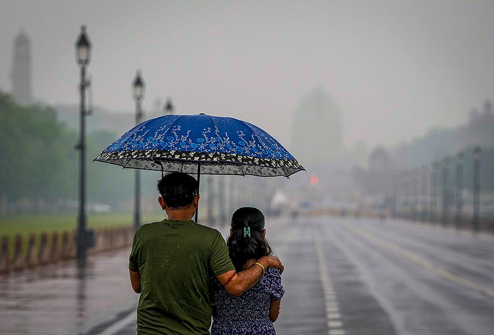 | Photo: PTI/Atul Yadav : Visitors make their way through the Kartavya Path amid rainfall, in New Delhi. The weather office has issued a yellow alert for the city. 