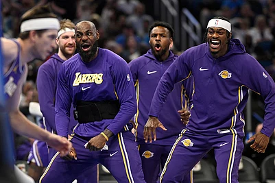 | Photo: AP/Phelan M. Ebenhack : Los Angeles Lakers forward LeBron James, second from front right, and forward Jarred Vanderbilt, right, react after a dunk by guard Austin Reaves, left, during the first half of an NBA basketball game against the Orlando Magic in Orlando, Fla.