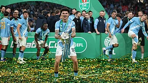AP Photo : Manchester City's Nico O'Reilly celebrates with the trophy after winning the English League Cup final soccer match between Arsenal and Manchester City in London, Sunday, March 22, 2026.